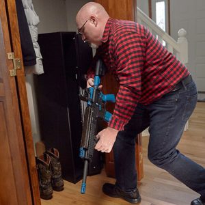 man accessing hidden gun safe in a closet