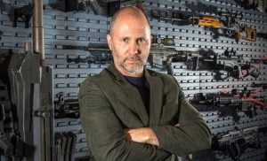 Tom Kubiniec in front of gun wall